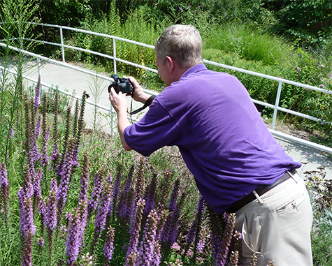 Richard S (Butterfly House) takes a picture of a butterfly in front of the Butterfly House.